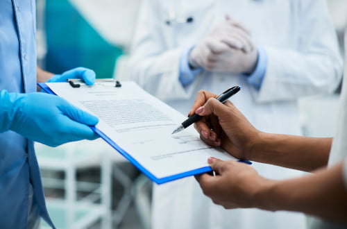 Patient signing a dental form before an appointment under the Canadian Dental Care Plan at a dental clinic in Vaughan