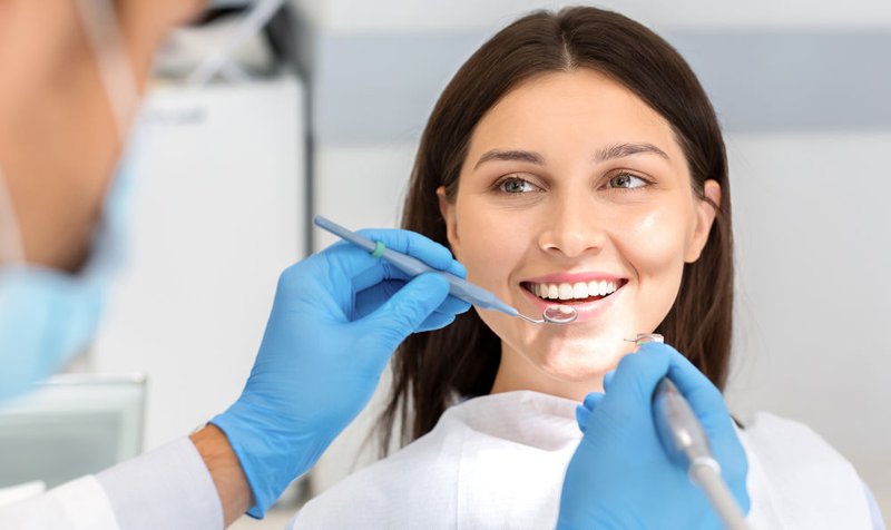 Smiling woman talking with a dentist during a routine dental check-up