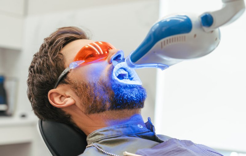Patient receiving professional in-office teeth whitening treatment