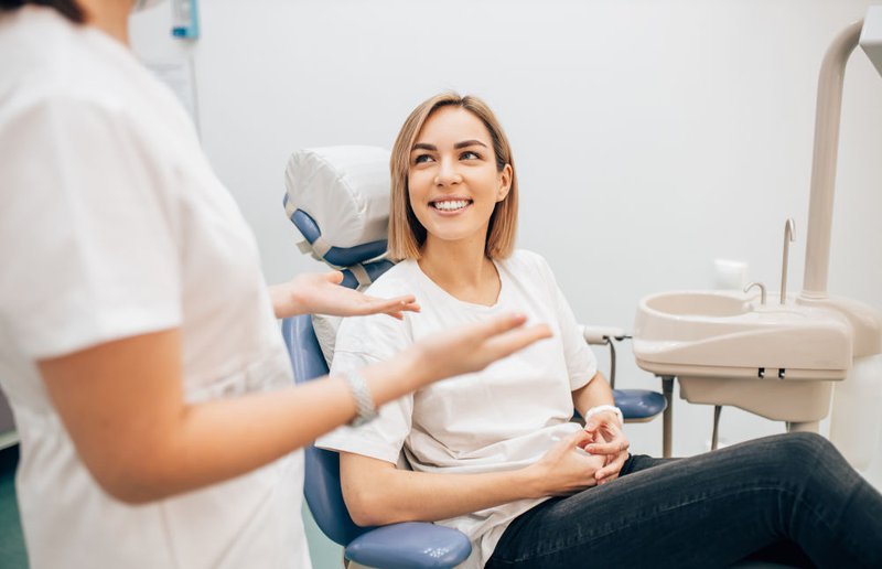 Charming young woman sitting in a dentist’s chair, engaging in consultation or treatment related to gum disease